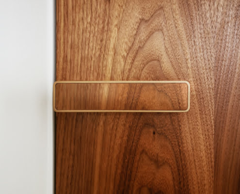 Door handle with veneer in the door decor